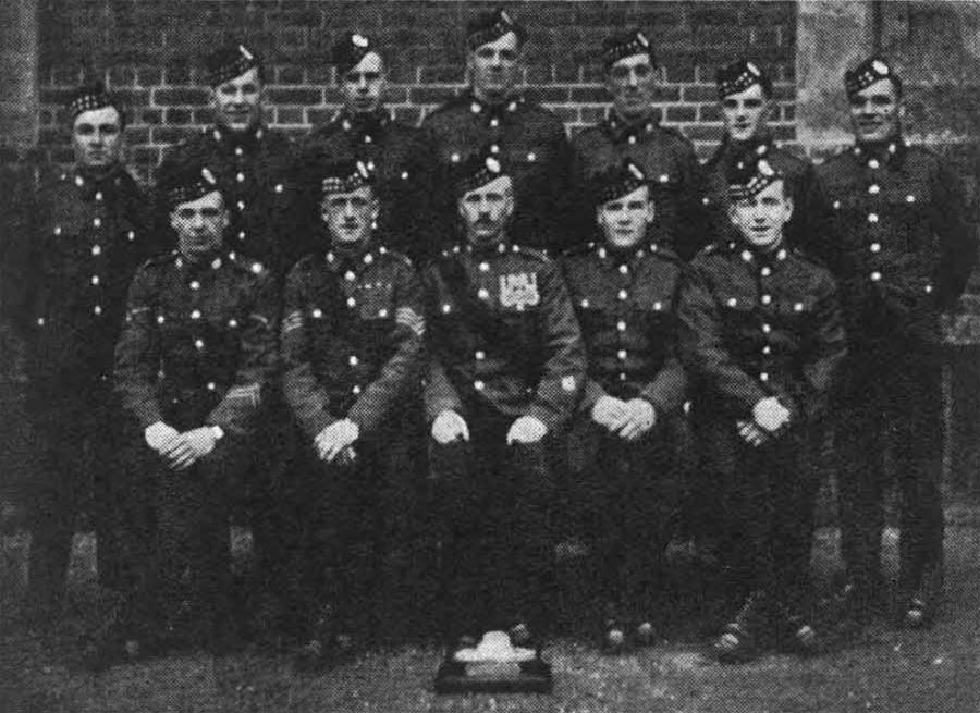 Royal Scots A Company Tug of War Team 1935. Back: Privates Mullarkey, Livingstone, Hope, Jackson, Donhaghy, Naysmith, Stewart. Front: L Corp Graham, Sgt Hynd (coach), CSM Mackay (trainer), L Corp Connelly, Private Duff