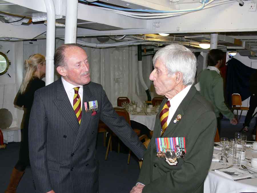 Reunion of survivors of the sinking of the Lisbon Maru on HMS Belfast. Can you name any the men in this picture?