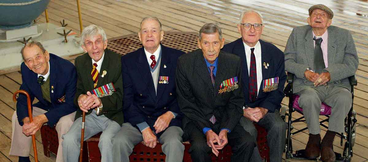 Reunion of survivors of the sinking of the Lisbon Maru on HMS Belfast.  Charles Jordan is on the far left. Can you name any of the other men in this picture?