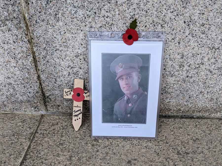 Picture of Private James (Jimmy) Alfred Maynard and memorial cross by the Sai Wan Memorial where Jimmy is commemorated.